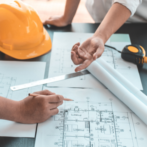 Blueprints being looked at and pointed to by contractors.